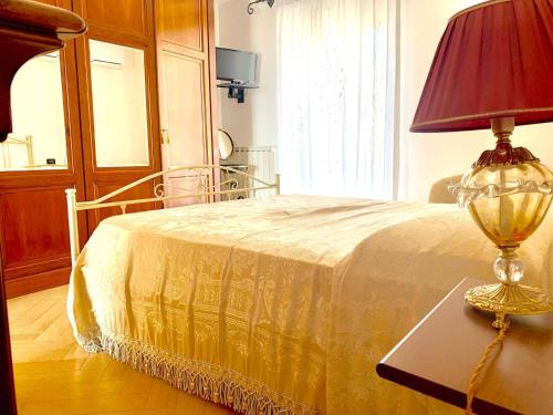 a bedroom with a bed with a lamp on a table at Graziosa Camera privata vista mare in centro in Peschici