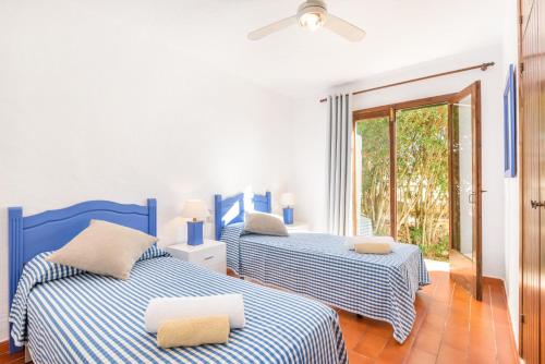 ビニベカにあるVilla BiniClaraの青と白のシーツが備わる客室のベッド2台