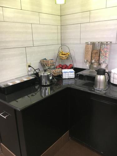 a kitchen with a black counter top with food on it at La Quinta Inn & Suites by Wyndham Louisville East in Louisville