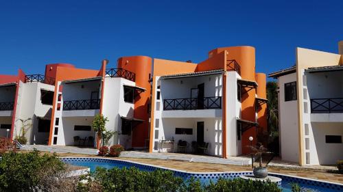 una fila de edificios de apartamentos con piscina en Paraiso de Maracajau 1, en Maracajaú