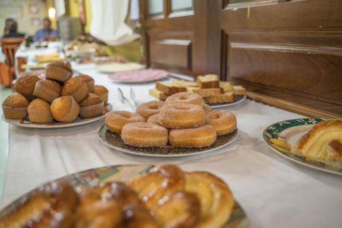 einen Tisch mit Teller mit Donuts und Gebäck in der Unterkunft Gran Hotel Rural Cela in Belmonte de Miranda