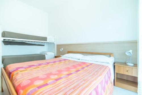 a bedroom with a bed with a colorful blanket at Residence Comfort in Lido di Jesolo