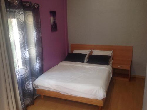 1 dormitorio con 1 cama con sábanas blancas y ventana en L'Audycé, en Lezoux