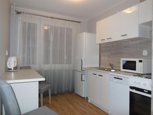 a kitchen with white cabinets and a white refrigerator at Pokoje Gościnne in Kraków