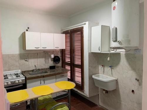 eine Küche mit weißen Schränken und einer gelben Arbeitsplatte in der Unterkunft Las Rosas - bulnes 121 in La Rioja