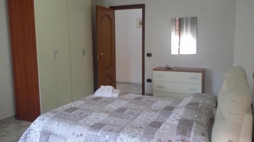 a bedroom with a bed and a dresser and a window at Sicily Guest House in Gela