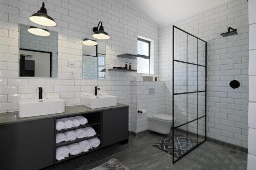 a white bathroom with two sinks and a toilet at Point B Guest House in Cape Town