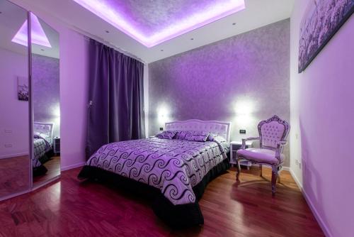 a purple bedroom with a bed and a chair at FASHION APARTMENT SILVER Bologna in Bologna