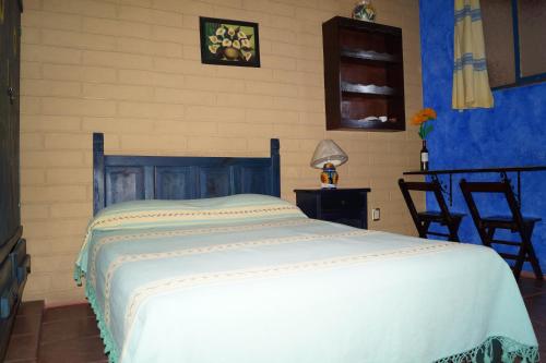 Un dormitorio con una cama blanca en una habitación. en Casa Xochimilco, en Oaxaca City