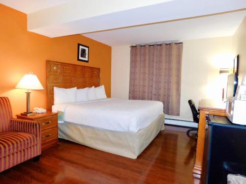 a hotel room with a bed and a television at Americas Best Value Inn & Suites Anchorage Airport in Anchorage