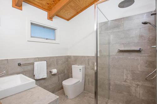 a bathroom with a toilet and a glass shower at Port Central No 3 in Port Campbell