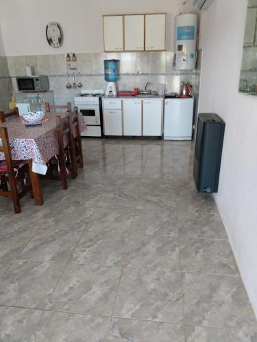 a kitchen with a table and a refrigerator in it at Atardecer Serrano in Huerta Grande