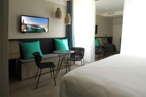 a hotel room with a bed and a table and chairs at Best Western Plus H&ocirc;tel La Joliette in Marseille