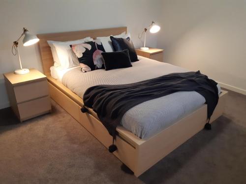 a bedroom with a large bed with two night stands at Port Central No 3 in Port Campbell
