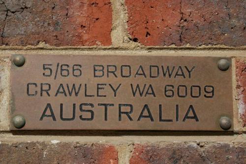 a sign on the side of a brick wall at B5 Crawley Apartment 1 BRM & Sleepout near UWA in Perth