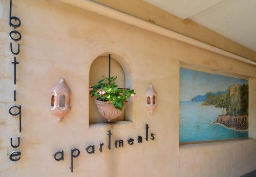 a sign on a wall with a plant in a vase at Villa San Michele (Official) in Port Douglas