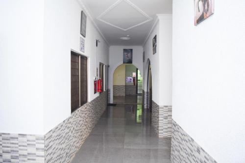 a hallway of a building with white walls and tile floors at 3A's Guest House in Oko Sombo