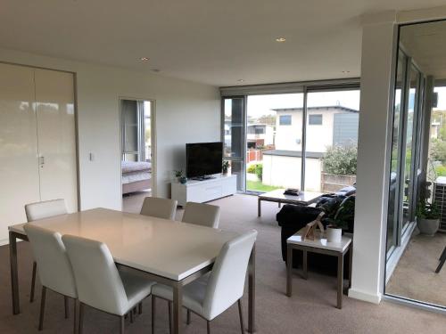 a dining room with a table and white chairs at Wyndham Resort Torquay in Torquay