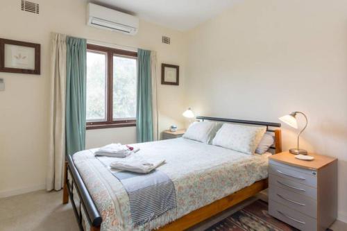 1 dormitorio con 1 cama con mesita de noche y ventana en B6 Crawley Apartment 1 BRM & Sleepout near UWA en Perth