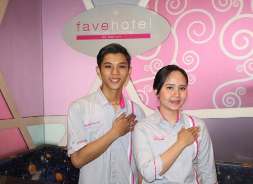 a man and a woman standing in front of a pink wall at favehotel Kelapa Gading in Jakarta