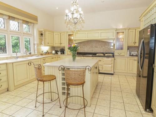 a kitchen with a center island with two bar stools at Richmond Hall in St Asaph