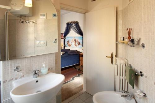 a bathroom with a sink and a toilet and a bedroom at B&B DolceVirginia in Rome