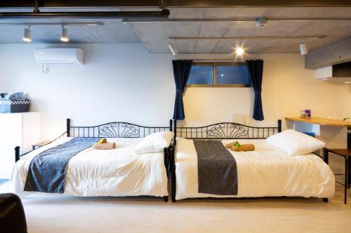 dos camas sentadas una al lado de la otra en una habitación en Laffitte Hirai Condominium Hotel en Tokio
