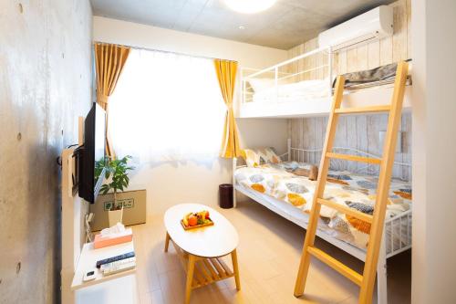 a small room with bunk beds and a table at Laffitte Hirai Condominium Hotel in Tokyo