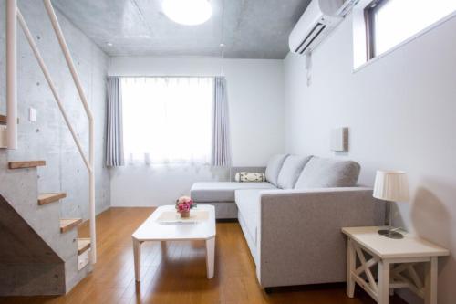 a living room with a couch and a table at Laffitte Hirai Condominium Hotel in Tokyo