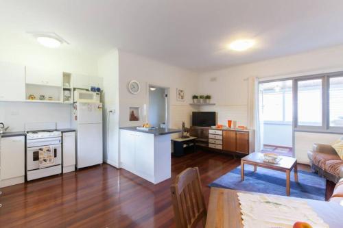 a living room with a kitchen and a living room with a couch at B7 Crawley Apartment 1 BRM & Sleepout near UWA in Perth