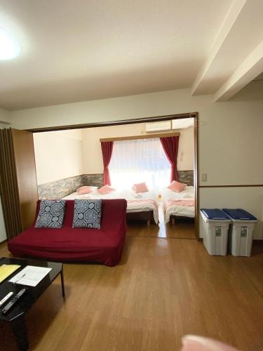 a living room with two beds and a red couch at Laforet Tokaichi in Hiroshima