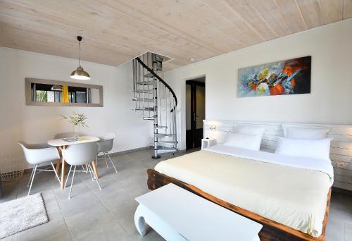 1 dormitorio con 1 cama, mesa y sillas en TAPACALA INSOLITE en Cilaos