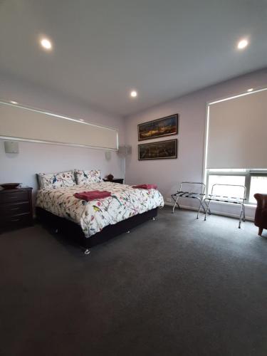 ein Schlafzimmer mit einem Bett und einem großen Fenster in der Unterkunft Spring Beach Garden Retreat in Spring Beach