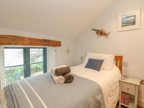 a bedroom with a bed with towels on it at Lantern Cottage in Padstow