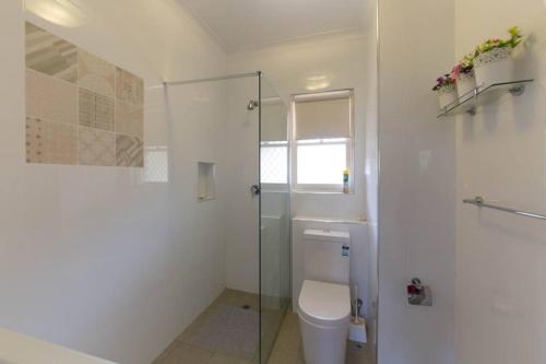 uma casa de banho com um WC e uma cabina de duche em vidro. em B9 Crawley Apartment 1 BRM & Sleepout near UWA em Perth