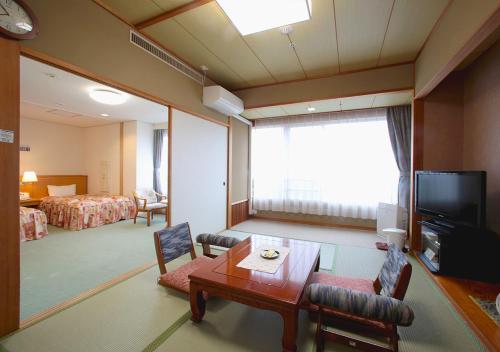 a room with a living room with a room with a bed at Shikinoyado SAHIMENO in Kawai