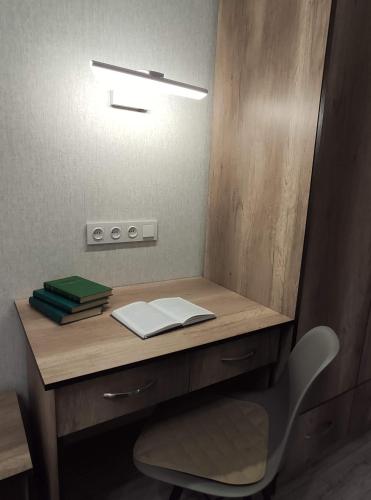 a wooden desk with a chair and a mirror at Lux Apartment Karakol Center in Karakol