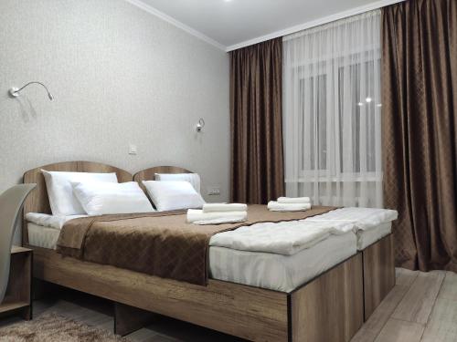 a bedroom with a large bed with white pillows at Lux Apartment Karakol Center in Karakol