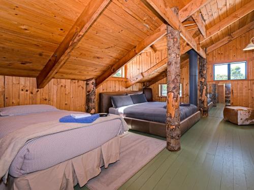 1 Schlafzimmer mit 2 Betten in einem Blockhaus in der Unterkunft Bruny Island Lodge in South Bruny