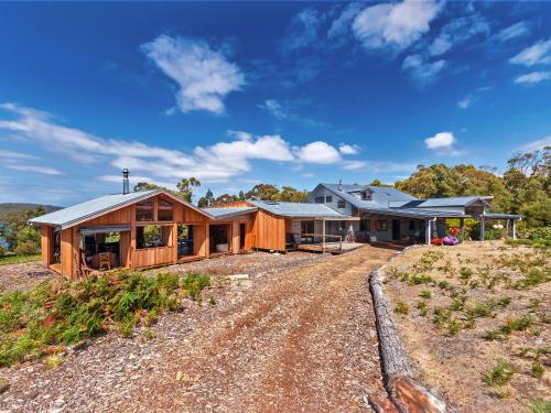 una casa en una colina con un camino de tierra en Bruny Island Lodge, en South Bruny