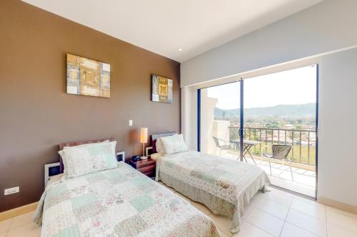 ein Schlafzimmer mit zwei Betten und einem Balkon in der Unterkunft Jaco Bay 3702 in Jacó