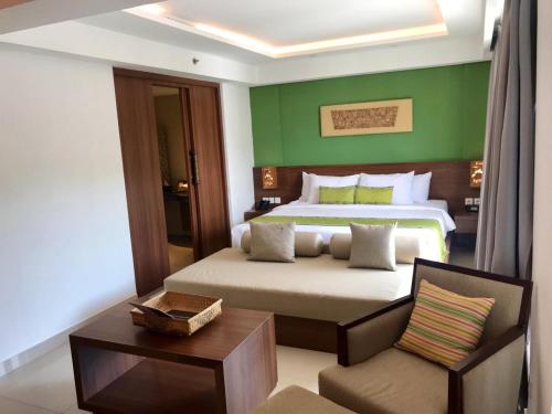 a bedroom with a bed with a green wall at d'primahotel Petitenget Seminyak 2 in Seminyak