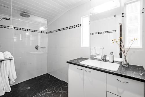 a white bathroom with a sink and a shower at Lucy's Cottage in Marananga