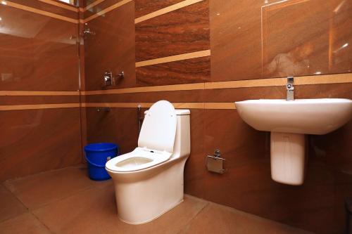 a bathroom with a toilet and a sink at CANDLE WOOD MUNNAR in Anachal