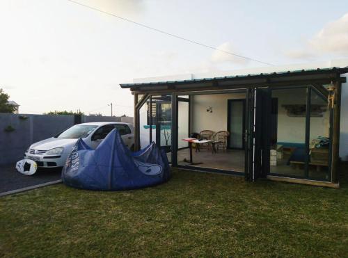 a house with a car parked in the grass at Cozy house for Kite & windsurfers (Le Morne) in Le Morne