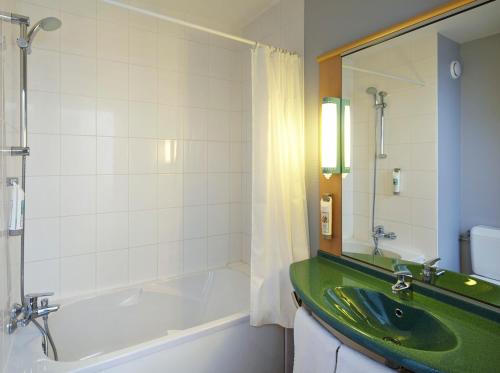 a bathroom with a green sink and a tub at ibis Chartres Ouest Luce in Chartres