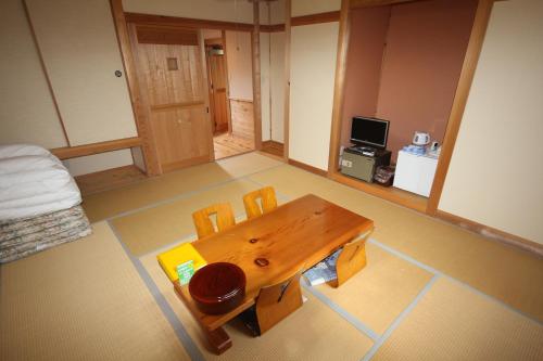 Cette chambre comprend une table et des chaises en bois. dans l'établissement Nature Resort in Shimanto, à Funato