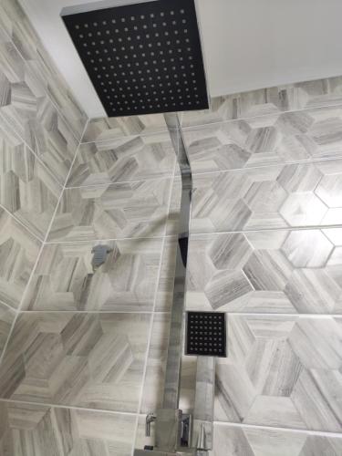 a bathroom with a shower with a tile floor at Lux Apartment Karakol Center in Karakol