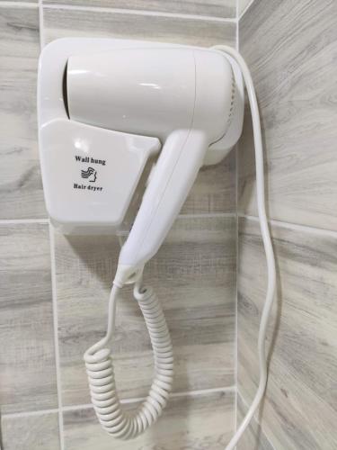 a white phone is hanging on a wall at Lux Apartment Karakol Center in Karakol