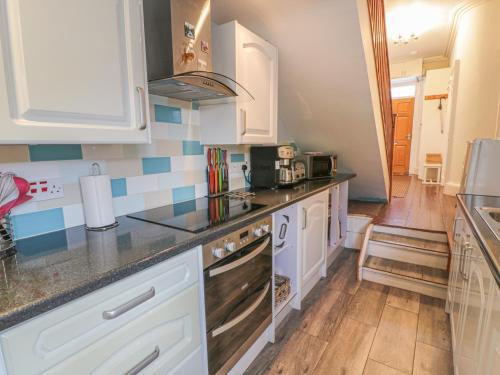 a kitchen with white cabinets and a black counter top at 79 Laurel Bank in Gatehouse of Fleet